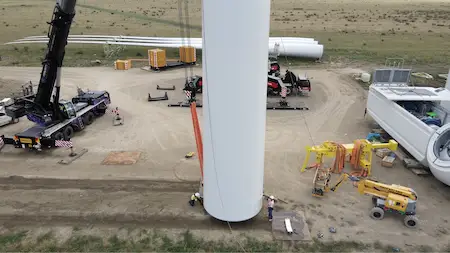 Workers and cranes in the installation of a windmill's base
